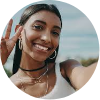 Smiling woman with the peace sign, showcasing a hair extension.