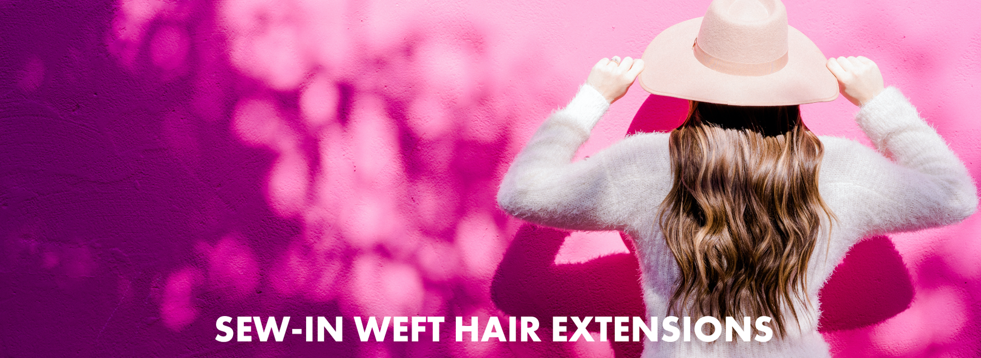 A lady is wearing a hat and white sweater with sew-in weft hair extensions on a pink background and white test stating 